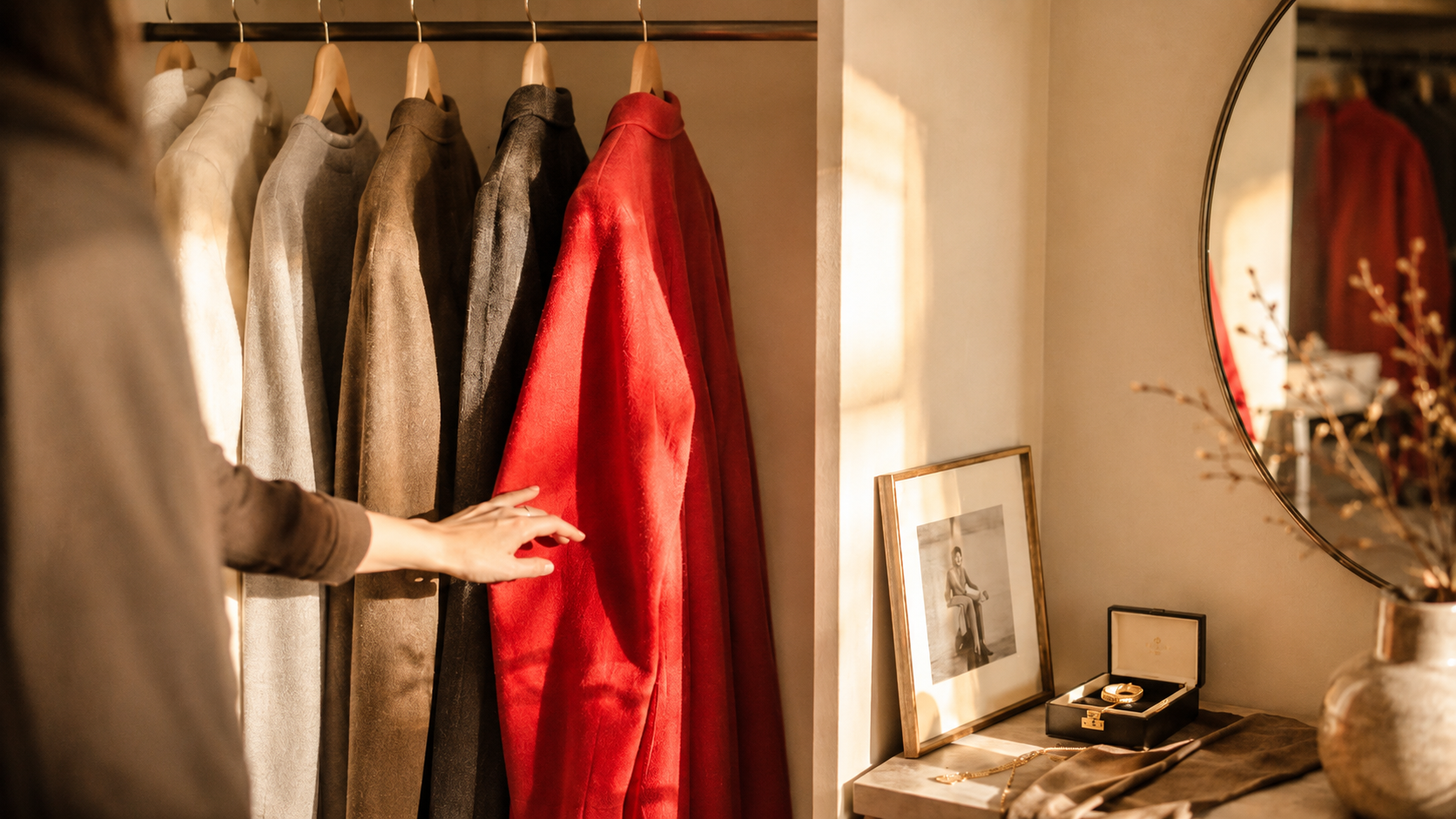 A hand reaching for a red garment on a wardrobe rail — the Dopamine Audit